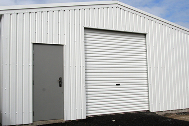A white building with a grey personal access door
